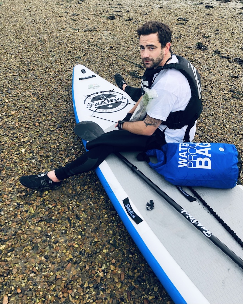 david haze on a beach with his paddle board