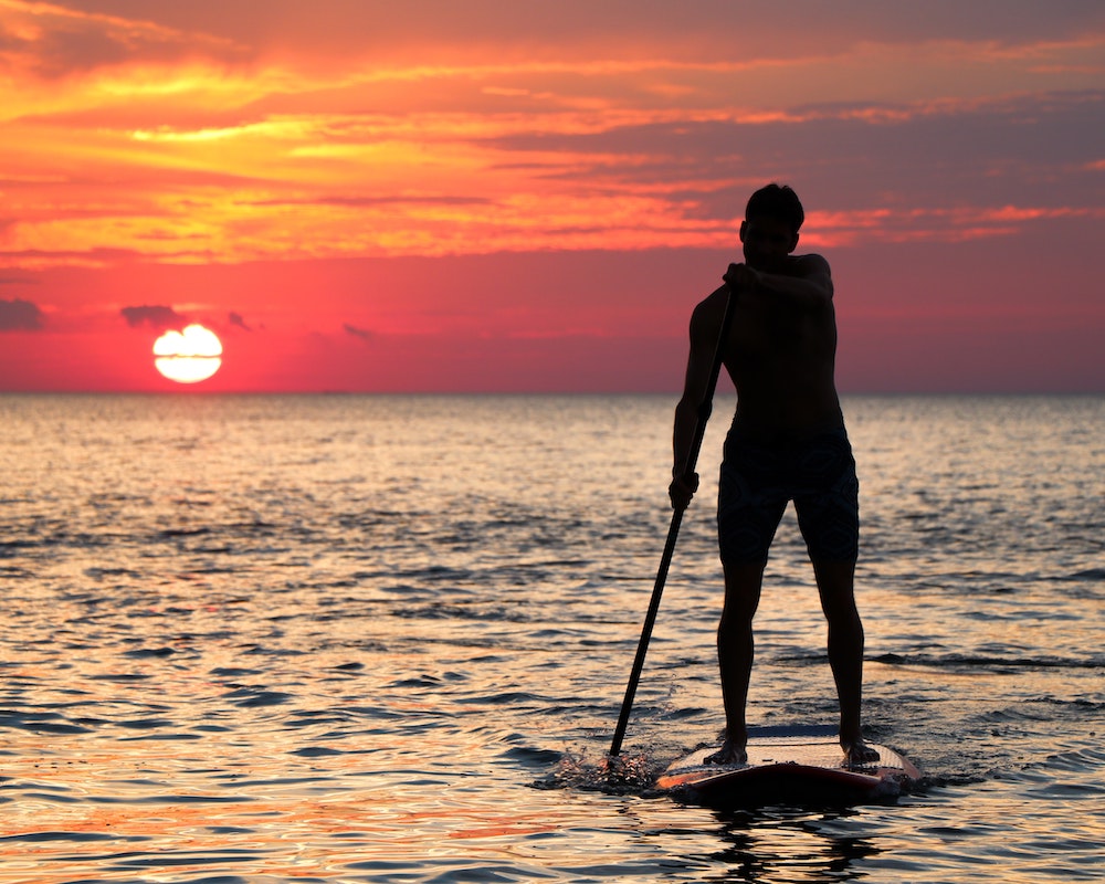 Woman on SuP board sunset